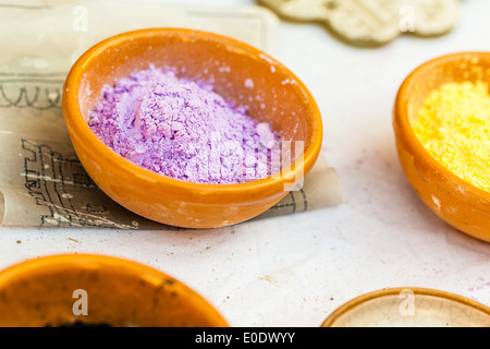 some vibrant dyes in terracotta bowls on a table Stock Photo