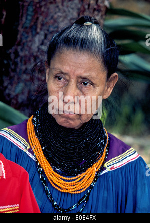 A Miccosukee Indian woman wears traditional clothing and necklace beads at her Seminole tribal village near The Everglades in Florida, USA. Stock Photo