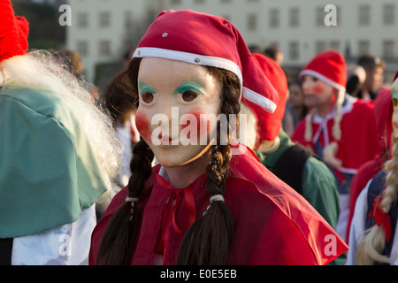 A photograph of an anonymous girl wearing a beautiful red riding hood costume at a carnival parade. Stock Photo