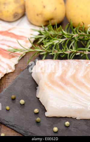 Raw cod with green rosemary in vertical format Stock Photo - Alamy