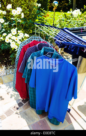 On a laundry stand several shirts hang to the dry outside. Energy savings in the everyday life, Auf einem Waeschestaender haenge Stock Photo