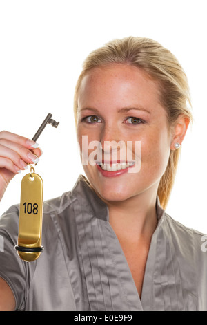 A young woman holds the key of a hotel room Stock Photo