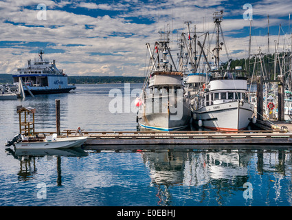 Fishing boats at marina, ferry in dist, going to Campbell River from Quathiaski Cove on Quadra Island, British Columbia, Canada Stock Photo