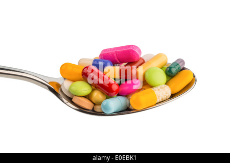 Many coloured tablets on a spoon. Symbolic photo for tablet addiction and abuse of drugs., Viele bunte Tabletten auf einem Loeff