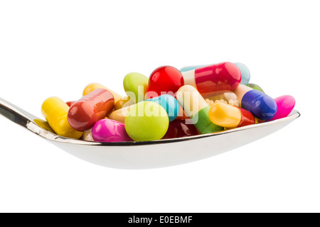 Many coloured tablets on a spoon. Symbolic photo for tablet addiction and abuse of drugs., Viele bunte Tabletten auf einem Loeff
