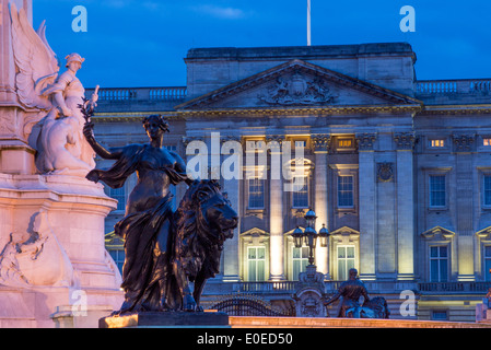 Buckingham Palace at night with Victoria Memorial statues in foreground London England UK Stock Photo