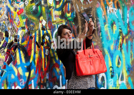 Tourist Woman at the John Lennon Wall in Prague Stock Photo