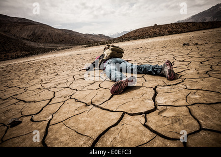 traveller lays on the dried ground Stock Photo