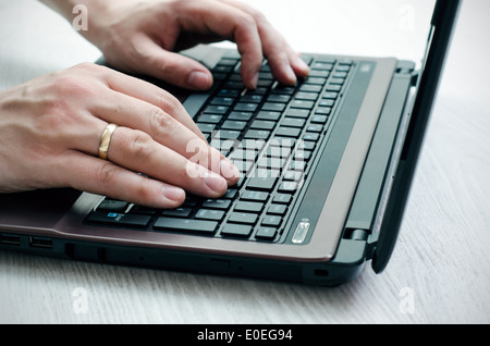 Man working with laptop on wooden background Stock Photo