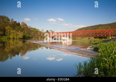 The old iron railway bridge over the river at sunset Stock Photo