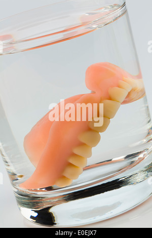 Denture m of water glass, symbolic photo for set of dentures and care, Zahnprothese m Wasserglas, Symbolfoto fuer Zahnersatz und