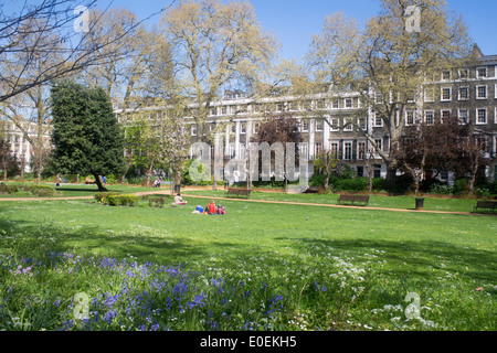 Gordon Square people relaxing in park gardens on a sunny spring day Bloomsbury London England UK Stock Photo
