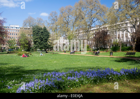 Gordon Square people relaxing in park gardens on a sunny spring day Bloomsbury London England UK Stock Photo