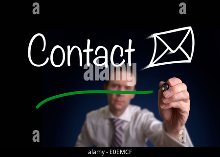 A businessman writing contact us on a screen. Stock Photo