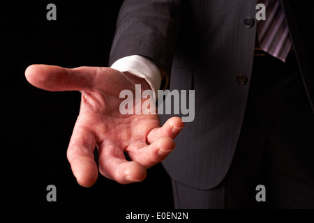 A businessman holding out his hand to shake the hand of another. Stock Photo