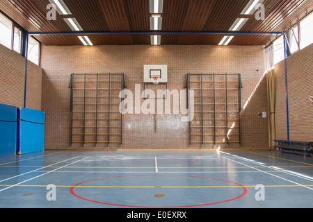 Interior of a gym at school, jumping high at the basket Stock Photo