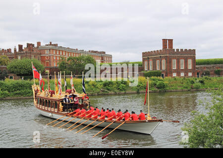 Tudor Pull.  Hampton Court Palace, East Molesey, Surrey, UK. 11th May, 2014. QRB Gloriana crewed by the Watermen's Company. Annual traditional rowing event between the Historic Royal Palaces of Hampton Court and the Tower of London. Thames cutters escort the Royal Barge Gloriana as she delivers a 'Stela' to the Governor of the Tower. This 'Stela' is a piece of ancient water pipe made from a hollowed tree trunk which stands on a base of timber from the old Richmond Lock and bears the coat of arms of the Worshipful Company of Watermen and Lightermen. Stock Photo