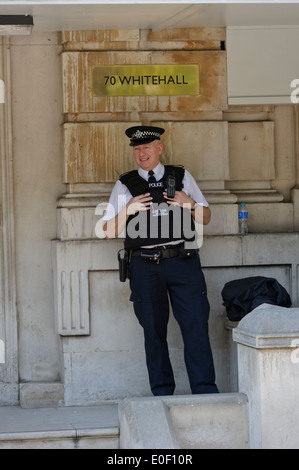 A Police officer on guard duty outside a Government Office on Whitehall, London, England. Stock Photo