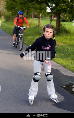 Roller skating child, girl skating on bicycle path Stock Photo