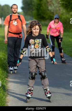Roller skating child, family on trail Stock Photo
