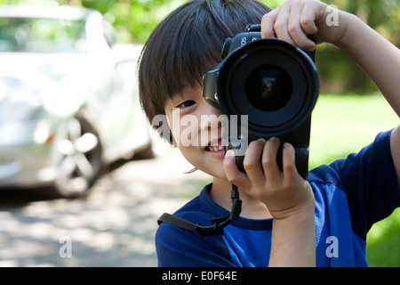 Child photographer, aged 5, using DSLR camera - USA Stock Photo