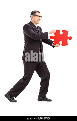 Businessman holding a piece of puzzle Stock Photo