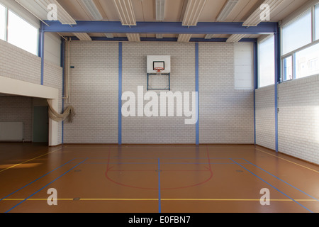 Interior of a gym at school, jumping high at the basket Stock Photo