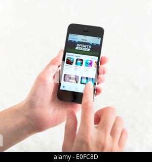 Woman looking for a new game apps using App Store on brand new black Apple iPhone 5S. Stock Photo