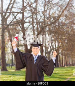 Mature man celebrating his graduation in park Stock Photo