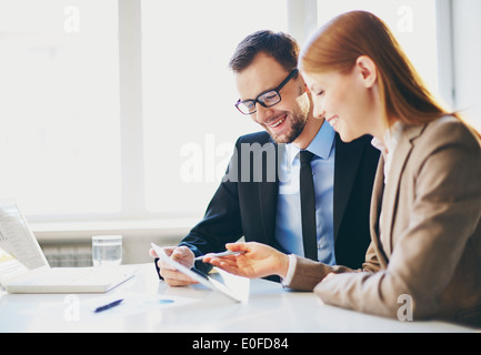Image of two young business partners using touchpad at meeting Stock Photo