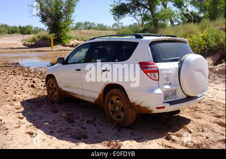 Toyota RAV4 SUV contemplates deep mud at a flooded of road river crossing in the Palo Duro cayon park, Texas, USA Stock Photo