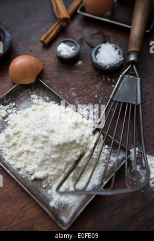 Ingredients for making pancakes, including eggs, flour cinnamon and a batterwhip Stock Photo