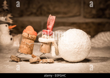 Concept Teamwork Snowball rolling, wine cork figures Stock Photo