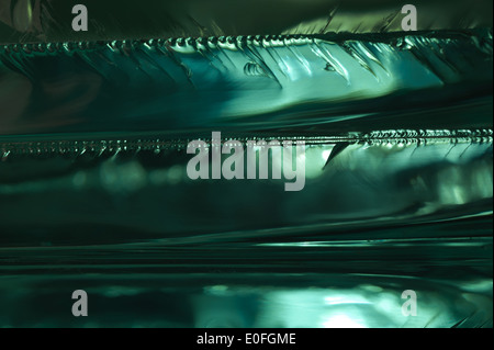 Sharp dangerous edge of plate glass internal reflection brings out green color and depth Stock Photo