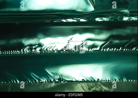 Sharp dangerous edge of plate glass internal reflection brings out green color and depth Stock Photo