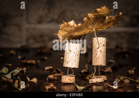 Concept two men carry leaves, wine cork figures Stock Photo