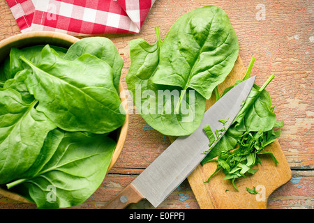 chopped spinach leaves on old wooden table Stock Photo