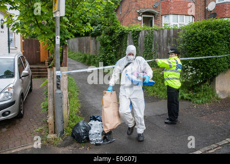 High Wycombe, UK. 12th May, 2014. A Thames Valley Police officer stands at a cordon on Underwood Road in High Wycombe as a search team member removes items from Lucas Wood after five injured in shooting. Credit:  Peter Manning/Alamy Live News Stock Photo