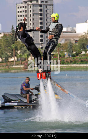 Istanbul. 12th May, 2014. Two stunt performers perform with water-propelled flyboards in Adana of Turkey on May 12, 2014. The engine with the applied water pressure can rise 7 meters high to the air. Performers fixed on the flyboard controlled the magnitude and direction of the water pressure to jump and fly above the water. Credit:  Cihan/Xinhua/Alamy Live News Stock Photo