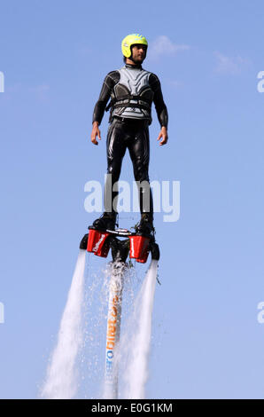 Istanbul. 12th May, 2014. A stunt performer performs with water-propelled flyboard in Adana of Turkey on May 12, 2014. The engine with the applied water pressure can rise 7 meters high to the air. Performers fixed on the flyboard controlled the magnitude and direction of the water pressure to jump and fly above the water. Credit:  Cihan/Xinhua/Alamy Live News Stock Photo