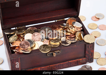 Treasure chest with euro of coins. Isolated on white background., Schatztruhe mit Euro Muenzen. Isoliert auf weissem Hintergrund Stock Photo