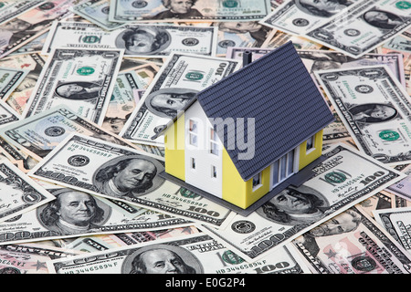 A house stands on a lot of dollar of bank notes, Ein Haus steht auf vielen Dollar Geldscheinen Stock Photo
