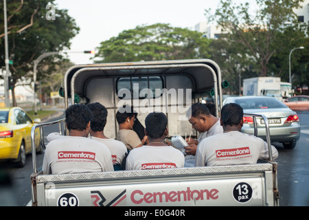 Migrant workers are transported to work in the back of a truck in Singapore Stock Photo