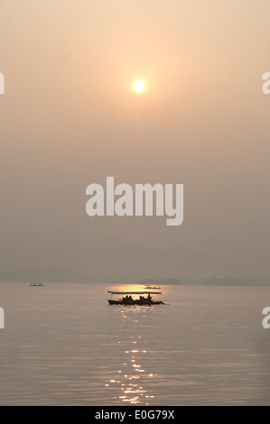 Sunset and boat silhouette, West Lake, Hangzhou, China Stock Photo