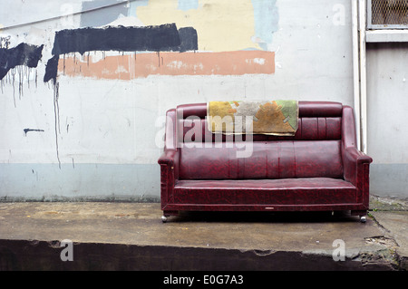 Old abandoned couch dumped on the street Stock Photo