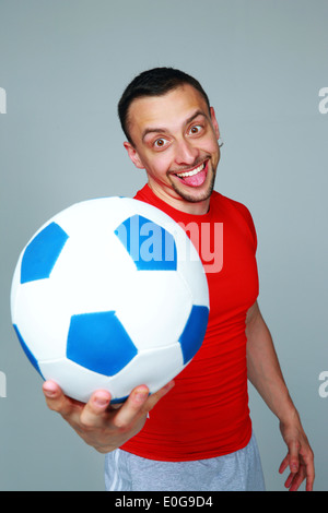 Crazy sportive man holding soccer ball over white background Stock ...