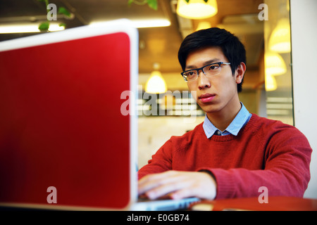 Smart asian man in glasses working on laptop in office Stock Photo