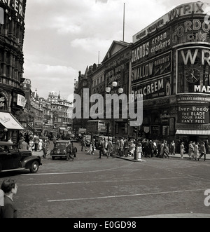 1950s. Historical picture showing people and thadvertising hoardings, Piccadilly Circus and Shaftesbury Avenue, London, England. Stock Photo