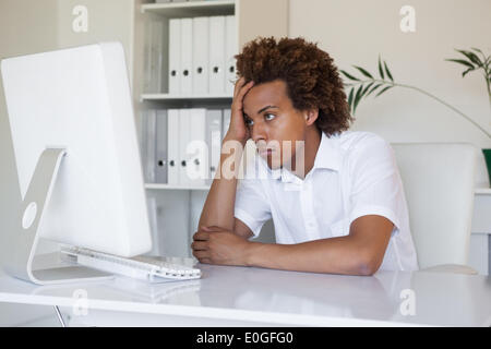 Casual stressed businessman looking at his computer Stock Photo