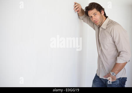 Casual worried businessman leaning on wall Stock Photo